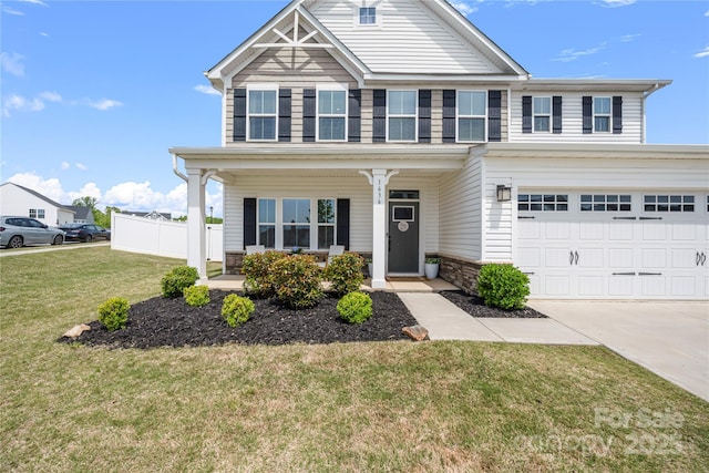 view of front of property with covered porch, fence, a front lawn, concrete driveway, and an attached garage