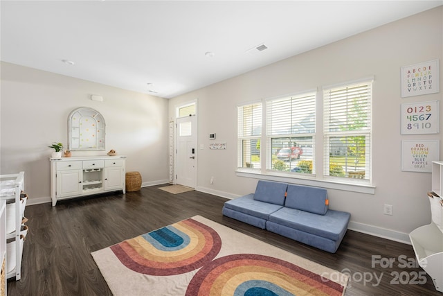 living area with baseboards, dark wood finished floors, and visible vents