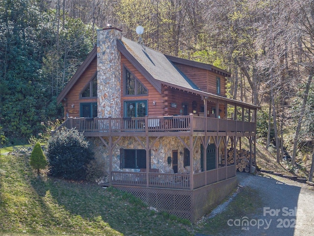 90 Junco Trl, Waynesville, NC 28785 - exterior space with a wooden deck, log siding, stone siding, a view of trees, and a chimney