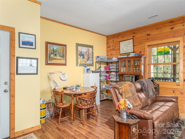 90 Junco Trl, Waynesville, NC 28785 - living area featuring wooden walls, crown molding, visible vents, baseboards, and wood finished floors