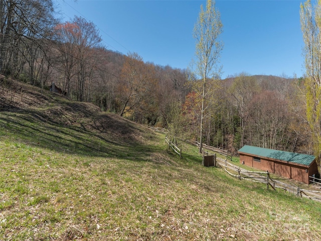 90 Junco Trl, Waynesville, NC 28785 - view of yard with an outdoor structure, a forest view, cooling unit, a pole building, and fence