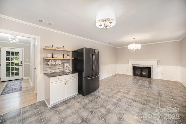 kitchen with freestanding refrigerator, dark countertops, a chandelier, ornamental molding, and open shelves