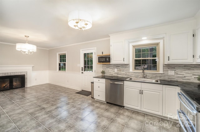 kitchen with appliances with stainless steel finishes, a sink, a chandelier, dark countertops, and crown molding
