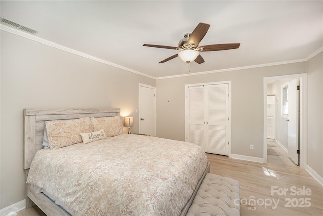 bedroom with a closet, ornamental molding, baseboards, light wood-style flooring, and ceiling fan