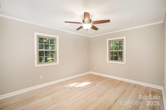 empty room with baseboards, light wood-type flooring, a ceiling fan, and crown molding