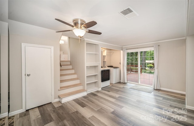 unfurnished living room featuring stairway, wood finished floors, ceiling fan, baseboards, and ornamental molding