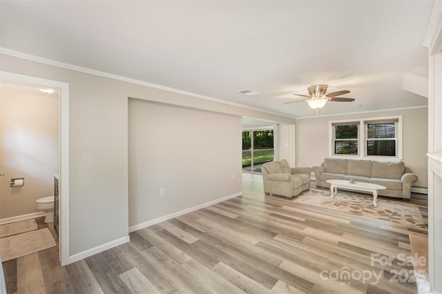 living area featuring crown molding, a ceiling fan, light wood-style floors, and baseboards