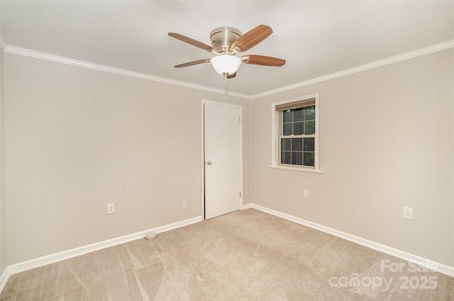 spare room featuring ceiling fan, ornamental molding, light colored carpet, and baseboards