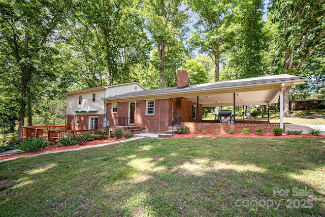 split level home featuring brick siding, a chimney, a front lawn, and an attached carport