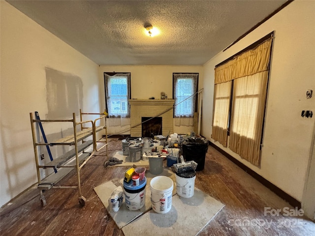 1703 Lowder St, Albemarle, NC 28001 - interior space with baseboards, a textured ceiling, a fireplace, and hardwood / wood-style flooring