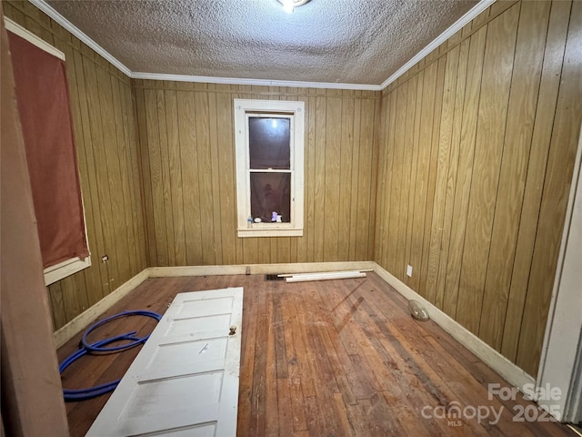 1703 Lowder St, Albemarle, NC 28001 - spare room featuring wood-type flooring, a textured ceiling, baseboards, and wooden walls