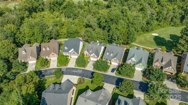 aerial view of property's location with nearby suburban area, a golf club, and a heavily wooded area