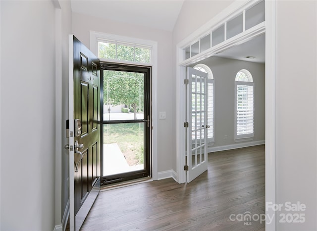 foyer with wood finished floors, french doors, vaulted ceiling, and baseboards