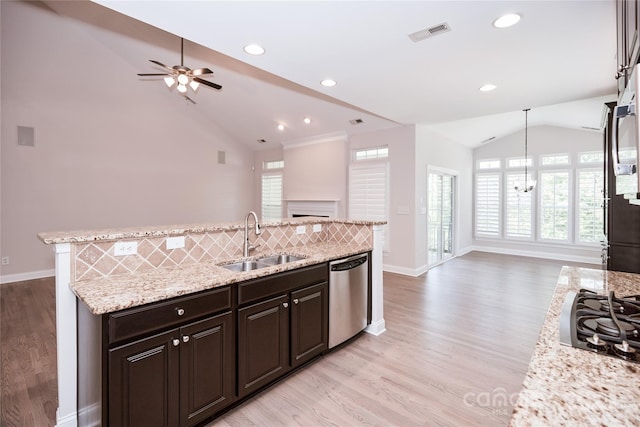 kitchen with stainless steel dishwasher, a sink, lofted ceiling, open floor plan, and black gas stovetop