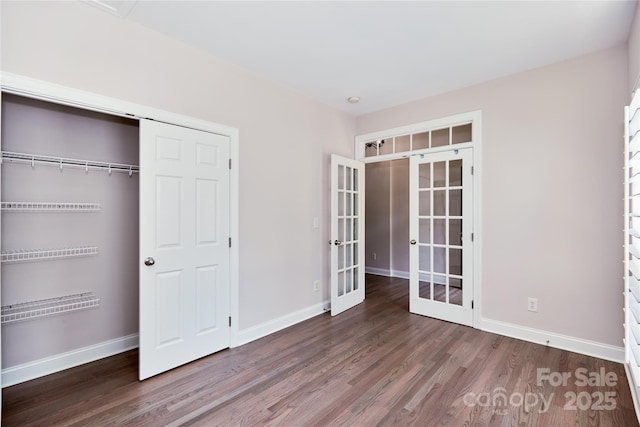 unfurnished bedroom featuring french doors, wood finished floors, and baseboards