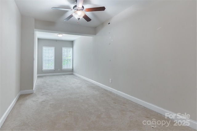 unfurnished room with carpet floors, baseboards, and a ceiling fan