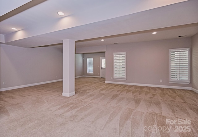 below grade area with light carpet, baseboards, and recessed lighting