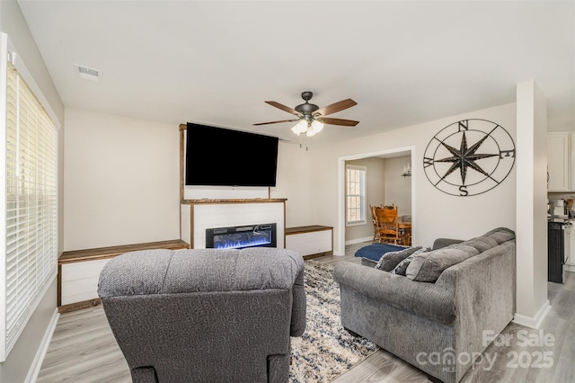 658 Morgan Rd, Albemarle, NC 28001 - living room with ceiling fan, visible vents, a glass covered fireplace, and light wood-style flooring
