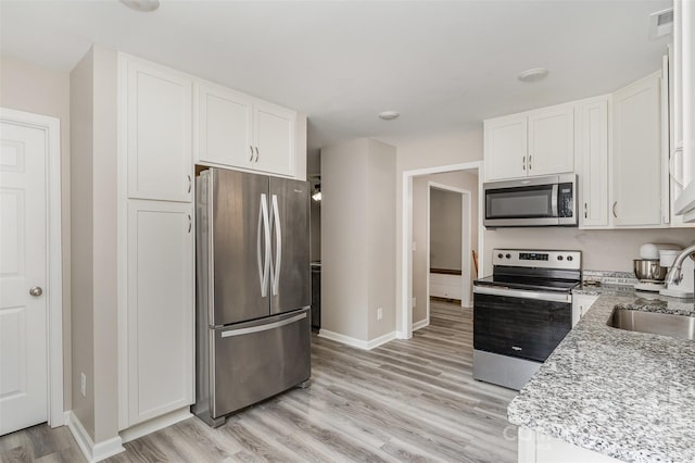 658 Morgan Rd, Albemarle, NC 28001 - kitchen with a sink, baseboards, white cabinets, light wood-style floors, and stainless steel appliances