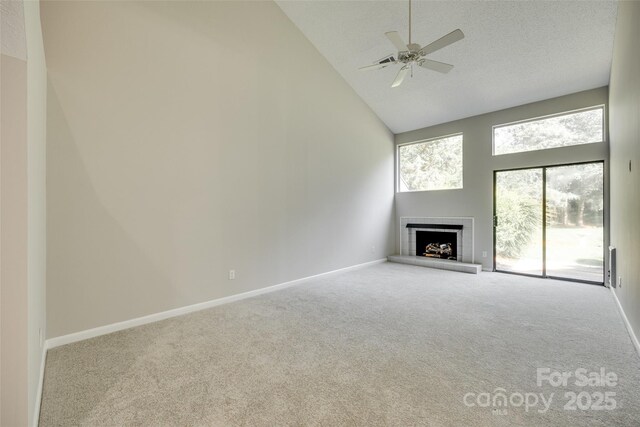 173 Greenridge Rd, Lake Wylie, SC 29710 - unfurnished living room featuring high vaulted ceiling, carpet floors, a fireplace with raised hearth, a ceiling fan, and baseboards