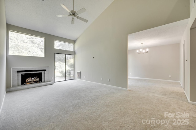 173 Greenridge Rd, Lake Wylie, SC 29710 - unfurnished living room featuring high vaulted ceiling, carpet flooring, a tiled fireplace, ceiling fan, and a chandelier