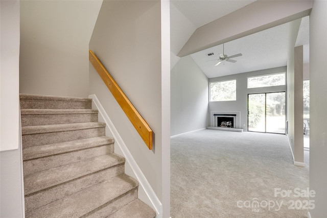 173 Greenridge Rd, Lake Wylie, SC 29710 - stairs with a ceiling fan, carpet, a fireplace with raised hearth, high vaulted ceiling, and baseboards