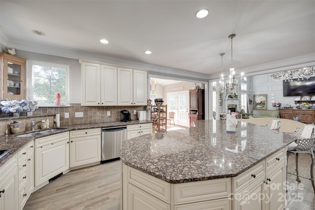 kitchen featuring a sink, a healthy amount of sunlight, stainless steel dishwasher, and open floor plan