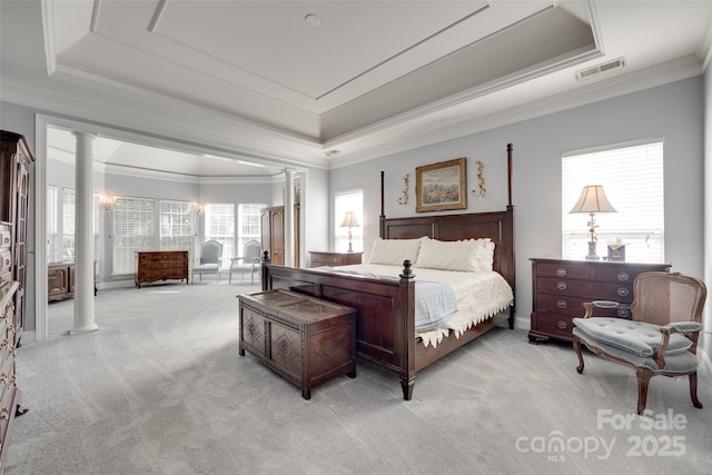 bedroom featuring visible vents, light colored carpet, ornamental molding, a tray ceiling, and ornate columns