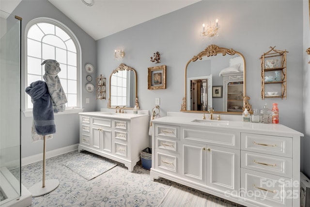 full bathroom with a sink, lofted ceiling, and two vanities