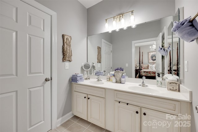 bathroom featuring a sink, tile patterned floors, ensuite bath, and double vanity