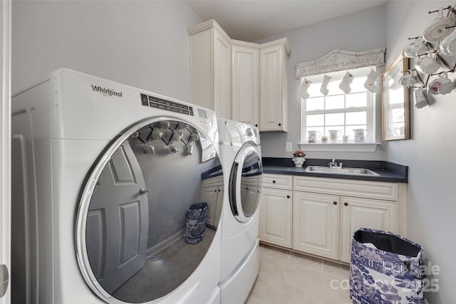 clothes washing area with a sink, light tile patterned floors, cabinet space, and washing machine and clothes dryer