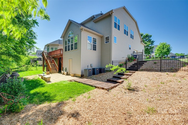 rear view of house with a deck, a patio area, central air condition unit, fence, and stairs
