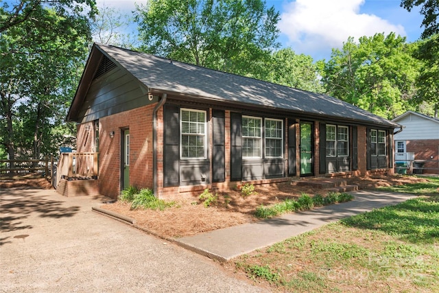 ranch-style house featuring brick siding and a shingled roof