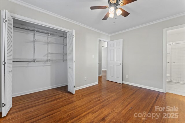 unfurnished bedroom with a closet, baseboards, crown molding, and wood finished floors