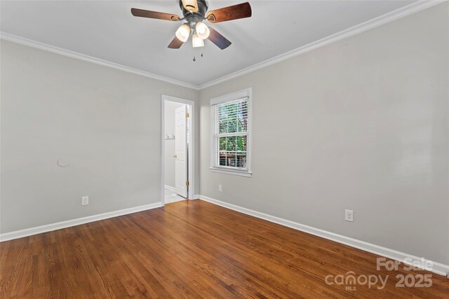 empty room featuring crown molding, baseboards, a ceiling fan, and wood finished floors