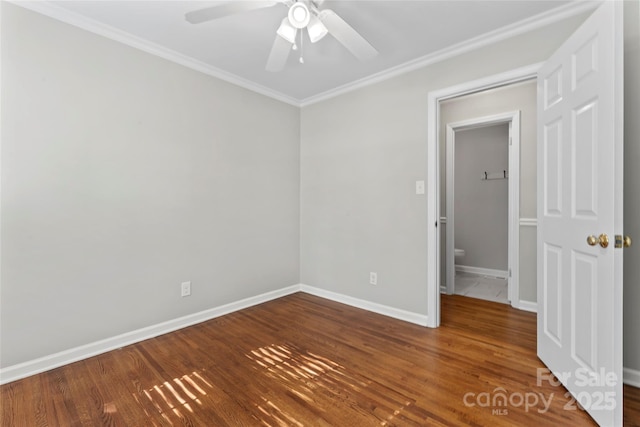 empty room with crown molding, baseboards, ceiling fan, and wood finished floors