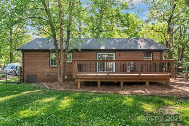 back of house with crawl space, a wooden deck, brick siding, fence, and a yard