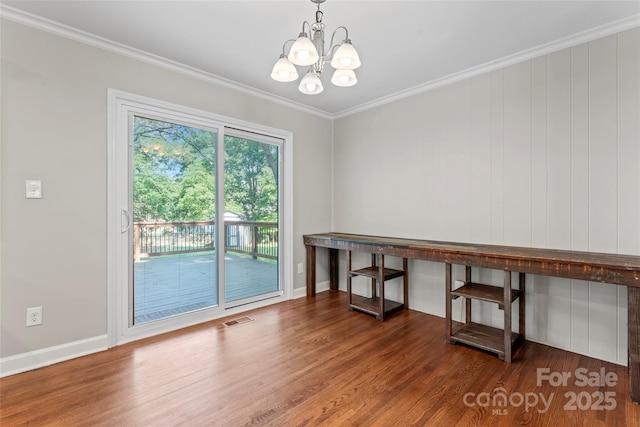 unfurnished dining area with crown molding, a notable chandelier, wood finished floors, and visible vents