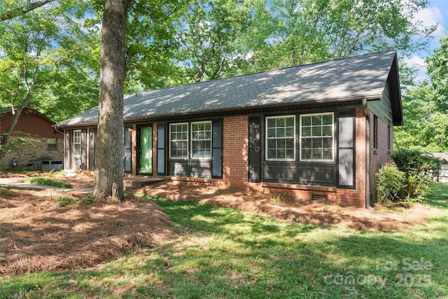 ranch-style house with brick siding, a shingled roof, and a front yard