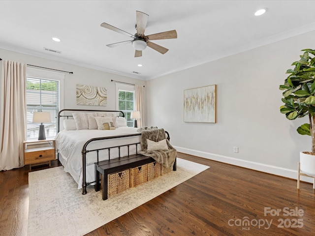 bedroom with ornamental molding, visible vents, multiple windows, and dark wood finished floors