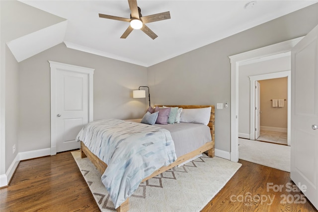 bedroom with wood finished floors, a ceiling fan, vaulted ceiling, and baseboards