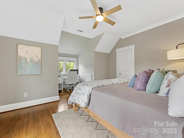 bedroom with visible vents, ceiling fan, baseboards, vaulted ceiling, and wood finished floors