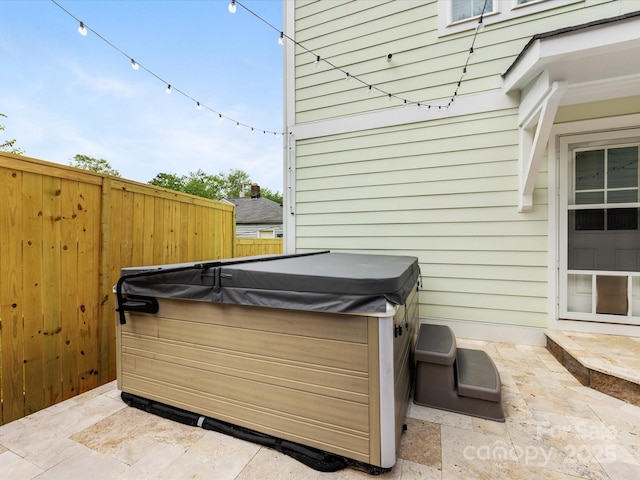 view of patio with fence and a hot tub