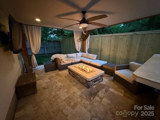 exterior space with ceiling fan, a fenced backyard, and an outdoor living space with a fire pit