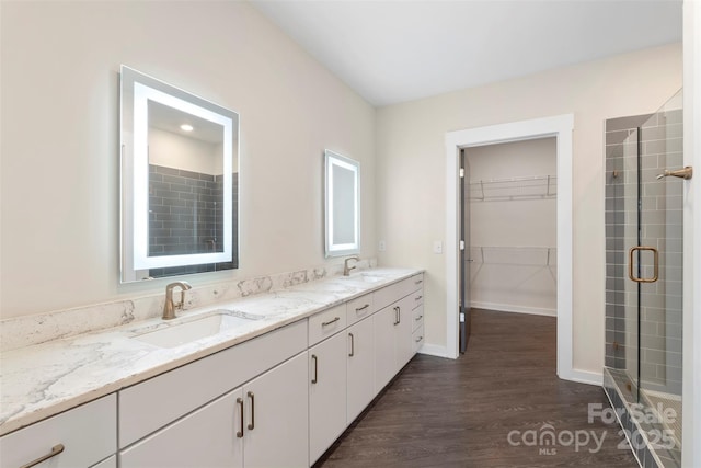3630 N Davidson St Unit 3301, Charlotte, NC 28205 - bathroom featuring a sink, wood finished floors, a spacious closet, and a shower stall