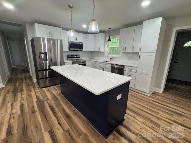 kitchen with a sink, decorative backsplash, stainless steel appliances, and dark wood-style flooring