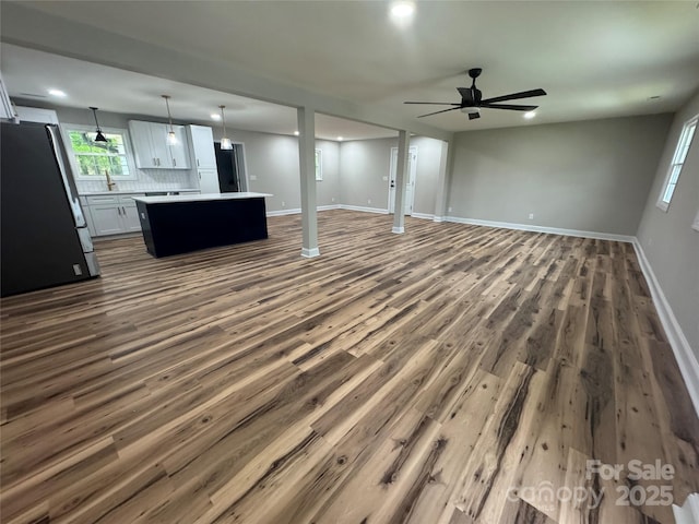 unfurnished living room with recessed lighting, ceiling fan, baseboards, and dark wood-type flooring