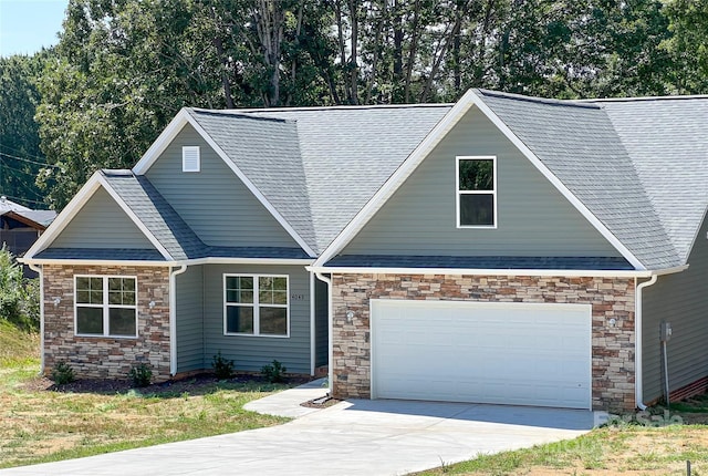 view of front facade featuring stone siding, a garage, concrete driveway, and a shingled roof