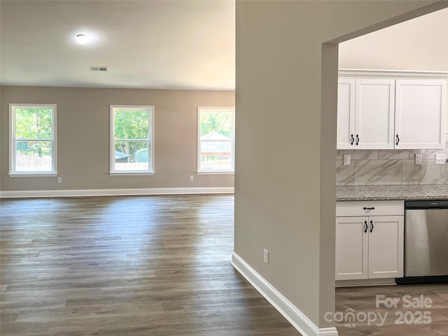 kitchen featuring baseboards, healthy amount of natural light, white cabinetry, and wood finished floors