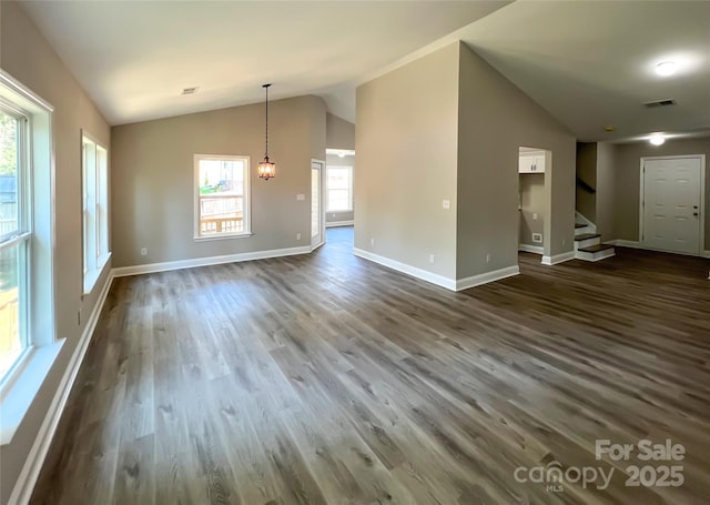 unfurnished living room with lofted ceiling, dark wood-type flooring, stairway, and baseboards